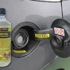 Butelka dodatku do oleju silnikowego diesel Venol Diesel Entfroster obok otwartego wlewu paliwa.