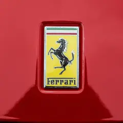 Jaki znaczek ma Ferrari? Czarny koń na żółtym tle, z napisem Ferrari.
