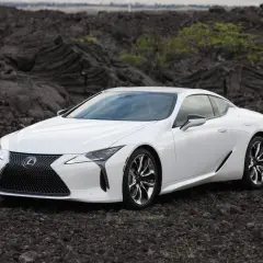 Biały Lexus LC 500 na tle wulkanicznych skał.