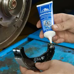 Nakładanie smaru ATE Plastilube na szczęki hamulcowe. To właściwy smar do przegubów i elementów układu hamulcowego.