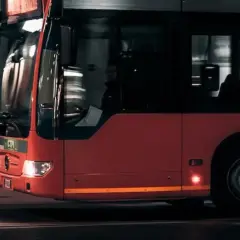 Czerwony autobus miejski w ruchu. Zastanawiasz się nad prawem jazdy kat D cena?