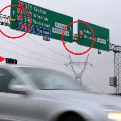 Znaki drogowe z lokalizacjami miast i zamontowane na nich żółte urządzenia pomiarowe.