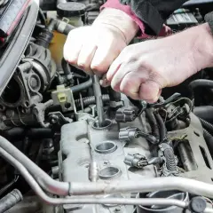Mechanik wymienia świece zapłonowe w silniku samochodu.