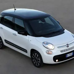 Biały Fiat 500 L z czarnym dachem, zaparkowany na szarym podłożu.