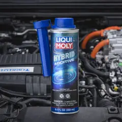 Dodatek do diesla Liqui Moly Hybrid Additive w puszce, na tle silnika hybrydowego. Dba o czystość układu paliwowego.