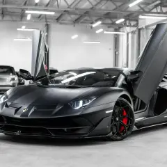 Matowy czarny Lamborghini Aventador SVJ z otwartymi drzwiami. Zastanawiasz się, ile kosztuje Lamborghini Aventador SVJ?