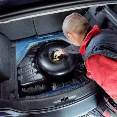 Mechanik sprawdza butlę LPG w bagażniku. Dowiedz się, ile kosztuje legalizacja butli LPG i jakie są wymagania.