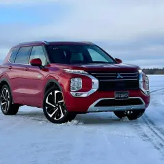 Czerwony Mitsubishi Outlander PHEV na zamarzniętym jeziorze, gotowy na zimowe przygody.