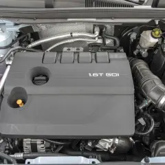 Silnik 1.6T GDI z widocznymi elementami osprzętu i płynów.