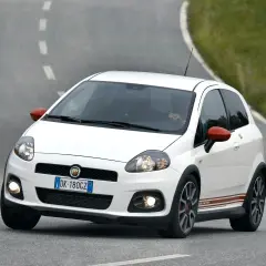 Biały Fiat Grande Punto Abarth na zakręcie drogi.