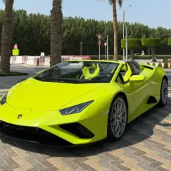 Jaskrawożółte Lamborghini z otwartym dachem, zaparkowane na brukowanej nawierzchni. Kto jest właścicielem tego cacka?