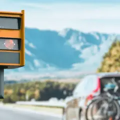 Fotoradar w Austrii, przypominający o tym, jak zapłacić mandat z Austrii przez internet. Samochód z rowerami na bagażniku.