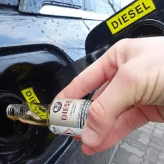 Dłoń wlewa dodatek do paliwa benzyna do baku diesla.