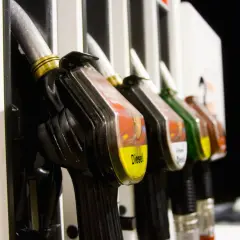 Na dystrybutorze paliw widać kilka pistoletów. Jeden z nich, z żółtą etykietą, jasno wskazuje, jaki kolor ma benzyna – jest żółta.