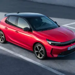 Czerwona Opel Corsa z czarnym dachem na parkingu. Zastanawiasz się, ile pali Opel Corsa? Ten model jest oszczędny.