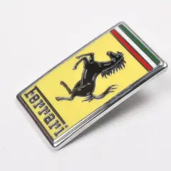 Oto jak wygląda znaczek Ferrari: czarny koń na żółtym tle, z napisem "ferrari" i włoską flagą.