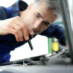 Mechanik sprawdza poziom płynu do wspomagania kierownicy.
