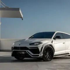 Biały Lamborghini Urus z czarnymi felgami, gotowy do galopu. Zastanawiasz się, ile koni ma Urus? Ten potwór ma ich 650!