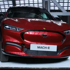 Czerwony Ford Mustang Mach-E w studiu z tabliczką "MACH-E".