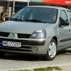Srebrny Renault Clio 2 z polskimi tablicami rejestracyjnymi WE 77297 jedzie po miejskiej ulicy.