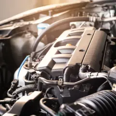 Zbliżenie na silnik samochodowy BMW E91, widoczne przewody i elementy mechaniczne.