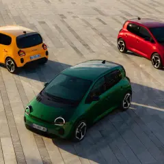 Trzy kolorowe Renault Twingo 2: zielone, żółte i czerwone, stoją na betonowej nawierzchni.