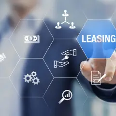 Dłoń dotyka ekranu z ikonami symbolizującymi leasing, pieniądze, klucze i umowę.