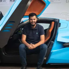 Młody mężczyzna siedzi w błękitnym Bugatti. Czy to on jest właścicielem tego cudu techniki?