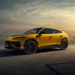 Żółty Lamborghini Urus na tle zachodzącego słońca. Ten SUV ma moc 650 KM, co czyni go potężnym zwierzęciem na kołach.