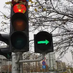 Sygnalizacja świetlna: czerwone światło na głównym sygnalizatorze i zielona strzałka w prawo na dodatkowym.