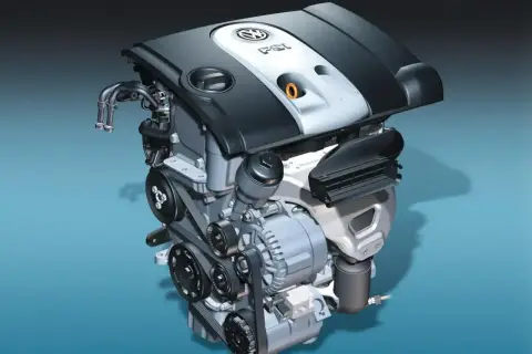Silnik Volkswagen 1.6 MPI z widocznymi paskami, alternatorem i osłoną.