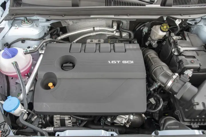 Silnik 1.6T GDI z widocznymi elementami osprzętu i płynów.