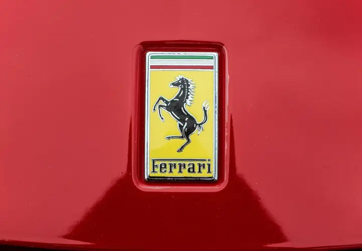 Jaki znaczek ma Ferrari? Czarny koń na żółtym tle, z napisem Ferrari.