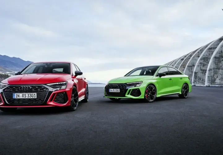 Dwa Audi RS 3 Sportback: czerwone i zielone, zaparkowane na zewnątrz.