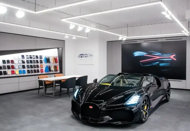 Czarny Bugatti w salonie, obok próbek skór i ekranu z grafiką. Ile jest Bugatti w Polsce? Trudno powiedzieć, ale ten wygląda na pierwszy.