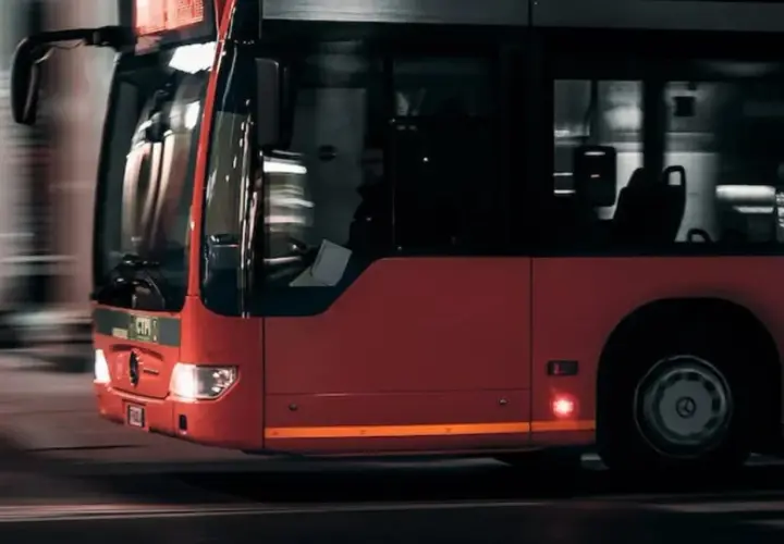 Czerwony autobus miejski w ruchu. Zastanawiasz się nad prawem jazdy kat D cena?
