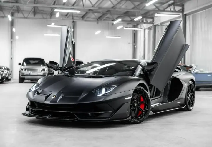 Matowy czarny Lamborghini Aventador SVJ z otwartymi drzwiami. Zastanawiasz się, ile kosztuje Lamborghini Aventador SVJ?