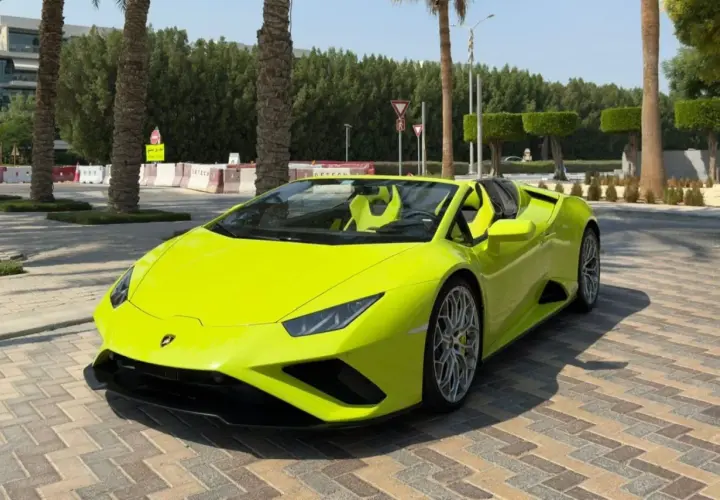 Jaskrawożółte Lamborghini z otwartym dachem, zaparkowane na brukowanej nawierzchni. Kto jest właścicielem tego cacka?
