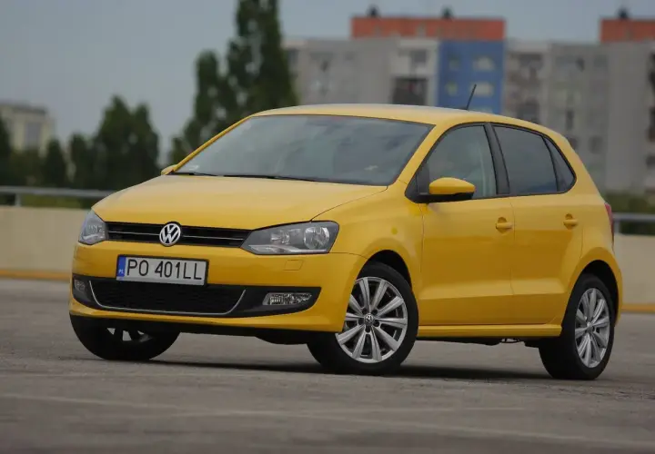 Żółty Volkswagen Polo na parkingu, idealny do miasta. Zastanawiasz się, ile pali ten model?