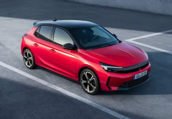 Czerwona Opel Corsa z czarnym dachem na parkingu. Zastanawiasz się, ile pali Opel Corsa? Ten model jest oszczędny.