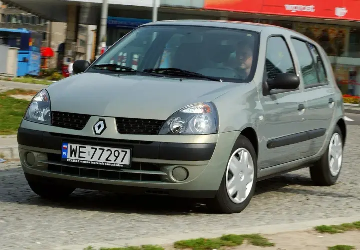 Srebrny Renault Clio 2 z polskimi tablicami rejestracyjnymi WE 77297 jedzie po miejskiej ulicy.