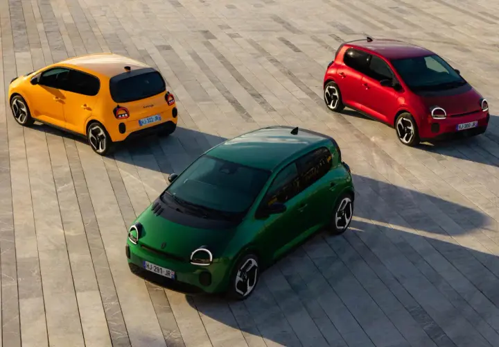 Trzy kolorowe Renault Twingo 2: zielone, żółte i czerwone, stoją na betonowej nawierzchni.