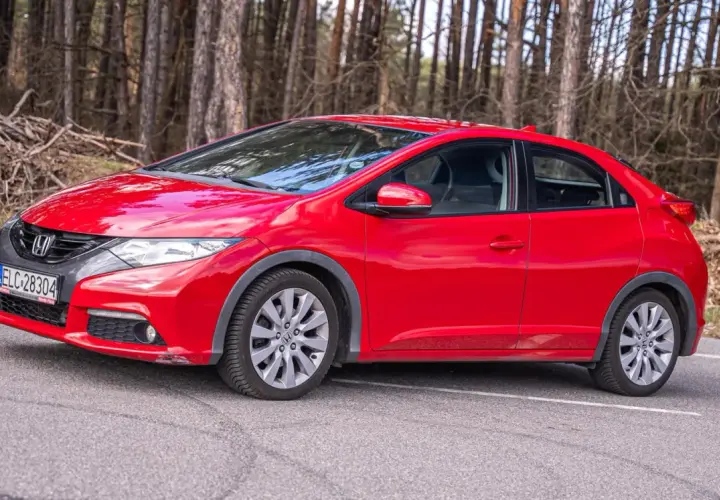 Czerwony Honda Civic IX na tle lasu.