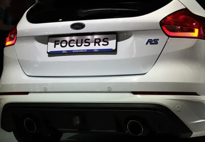 Tył białego Forda Focus RS z widocznymi światłami, napisem "FOCUS RS" i podwójnymi końcówkami wydechu.