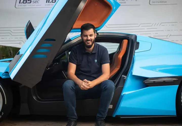Młody mężczyzna siedzi w błękitnym Bugatti. Czy to on jest właścicielem tego cudu techniki?