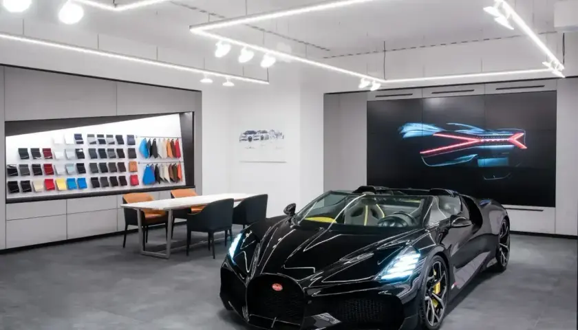 Czarny Bugatti w salonie, obok próbek skór i ekranu z grafiką. Ile jest Bugatti w Polsce? Trudno powiedzieć, ale ten wygląda na pierwszy.