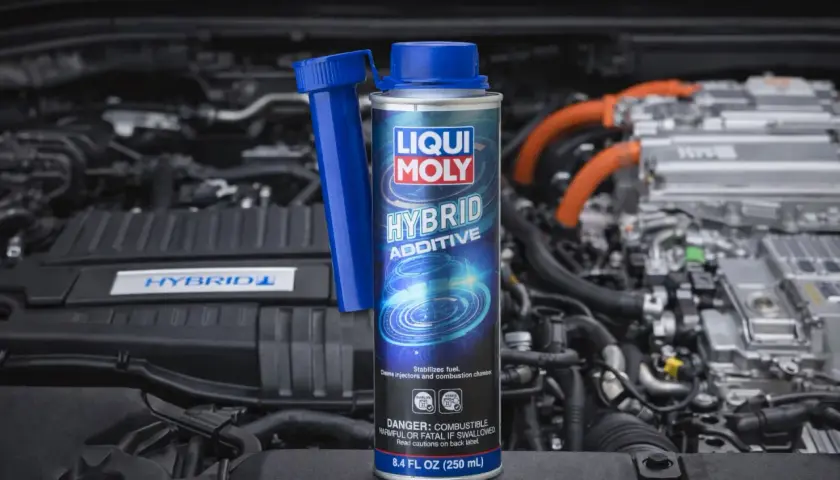 Dodatek do diesla Liqui Moly Hybrid Additive w puszce, na tle silnika hybrydowego. Dba o czystość układu paliwowego.