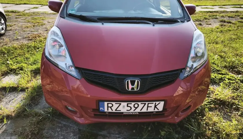 Czerwona Honda Jazz z tablicą RZ 597FK. Zastanawiasz się, jaki olej do Hondy Jazz 1.4 benzyna? Ten model zasługuje na najlepszy!