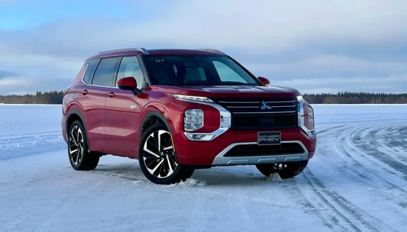 Czerwony Mitsubishi Outlander PHEV na zamarzniętym jeziorze, gotowy na zimowe przygody.