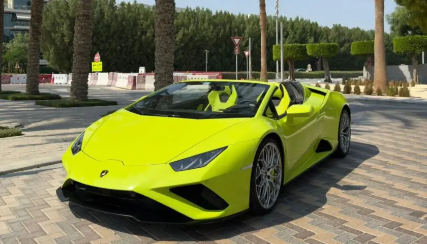 Jaskrawożółte Lamborghini z otwartym dachem, zaparkowane na brukowanej nawierzchni. Kto jest właścicielem tego cacka?